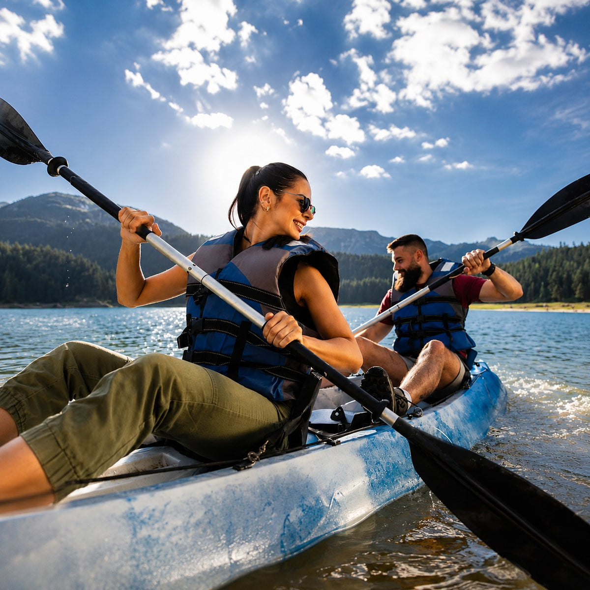 Two people kayaking on a lake with mountains in the background